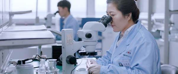 Laboratory worker using a microscope in the research department.